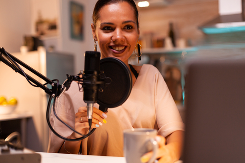 Woman recording a podcast in front of a microphone